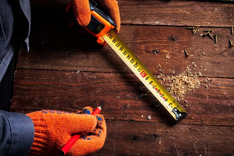 Mètre ruban et crayon de chantier pour mesurer une surface à isoler