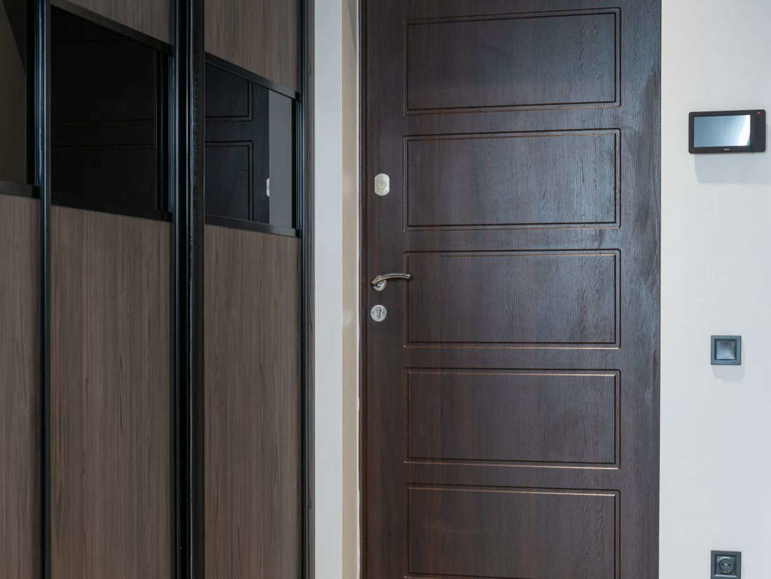 Porte palière pleine en bois dans une entrée d'appartement